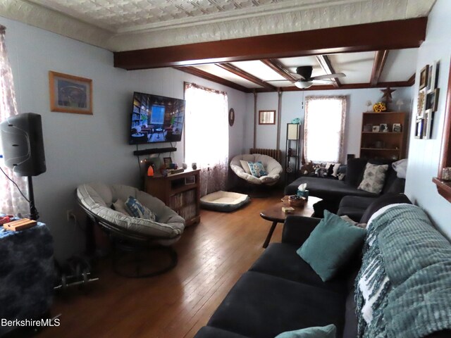 living area with hardwood / wood-style flooring, beamed ceiling, and a wealth of natural light