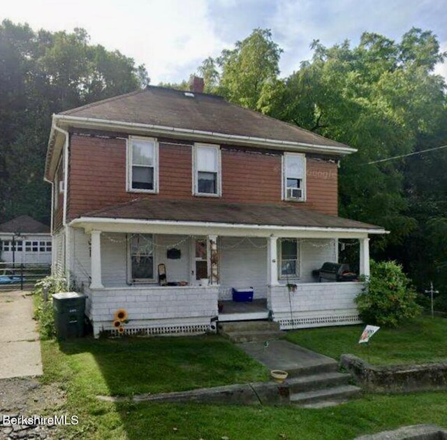 view of front of home featuring covered porch and a front lawn