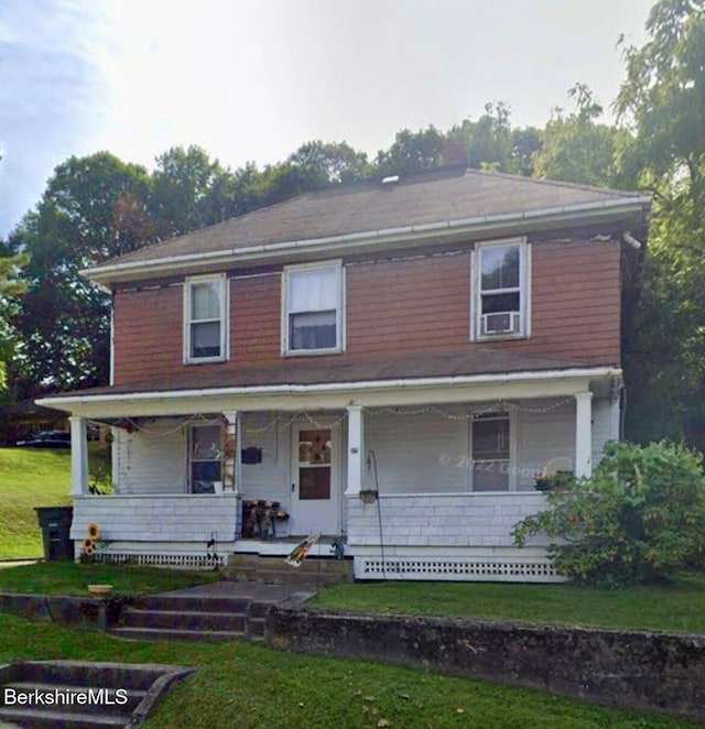 view of front facade featuring covered porch and a front yard