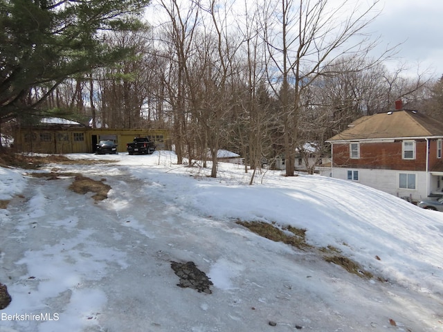 yard layered in snow with a carport