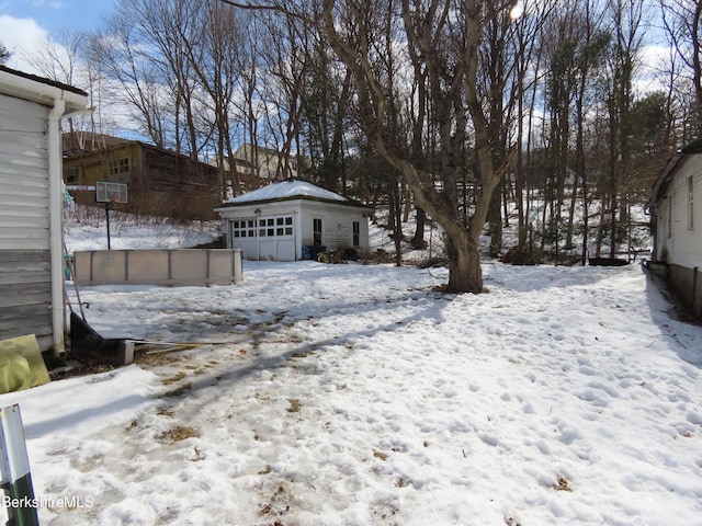 snowy yard with an outdoor structure and a garage