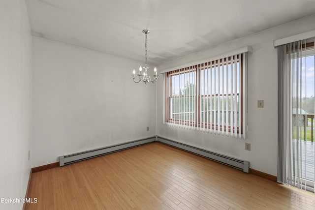 unfurnished room with a baseboard heating unit, a chandelier, wood finished floors, baseboard heating, and baseboards