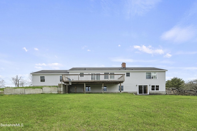back of house featuring a deck, a yard, and a chimney