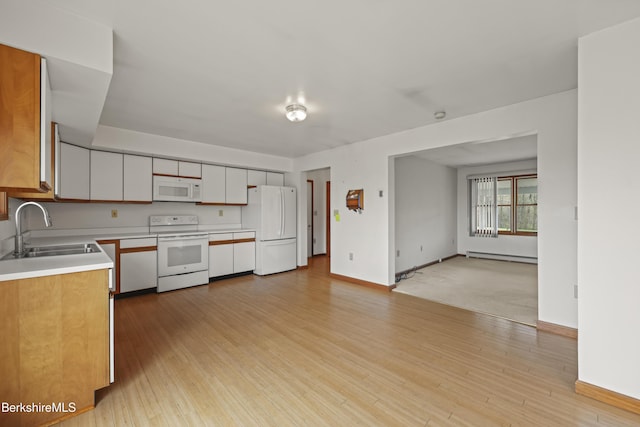 kitchen with white appliances, a sink, baseboard heating, light countertops, and light wood-style flooring