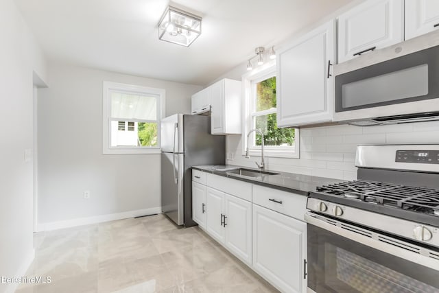 3 Burke Ave, Pittsfield, MA 01201 - kitchen featuring stainless steel appliances, backsplash, white cabinets, dark countertops, and light marble finish floors