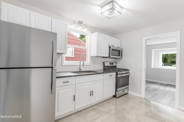3 Burke Ave, Pittsfield, MA 01201 - kitchen featuring appliances with stainless steel finishes, tasteful backsplash, white cabinets, dark countertops, and light marble finish floors