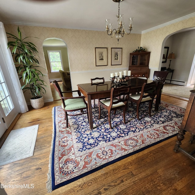 377 Pomeroy Ave, Pittsfield, MA 01201 - dining space featuring arched walkways, wood finished floors, crown molding, baseboard heating, and wallpapered walls