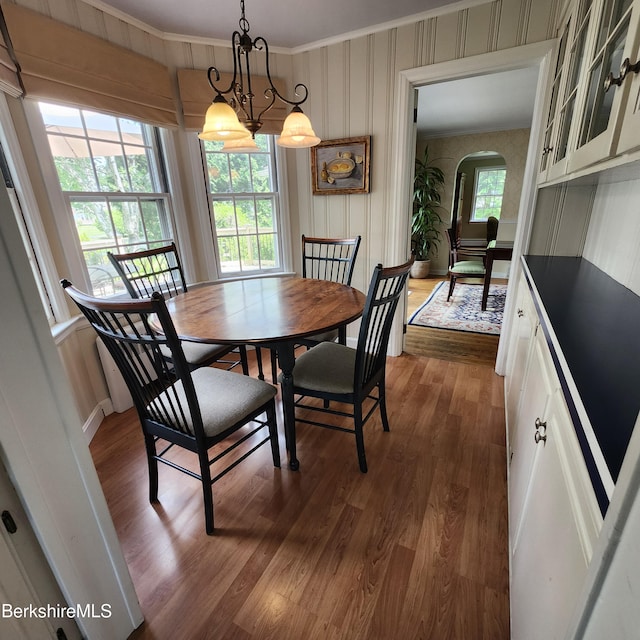 377 Pomeroy Ave, Pittsfield, MA 01201 - dining room featuring arched walkways, dark wood-type flooring, ornamental molding, and wallpapered walls