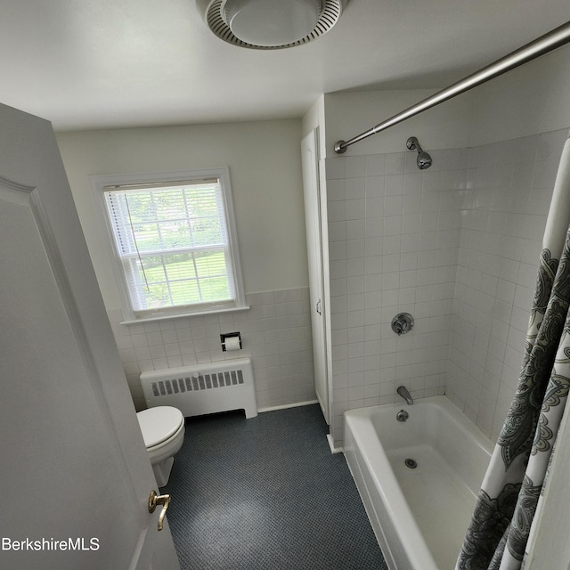 377 Pomeroy Ave, Pittsfield, MA 01201 - bathroom with radiator, tile walls, shower / bath combo, tile patterned floors, and a wainscoted wall