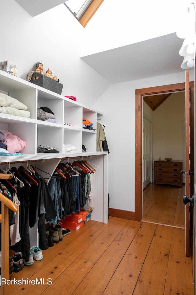 spacious closet with light hardwood / wood-style floors and a skylight