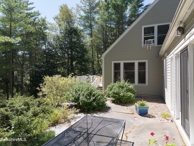 view of patio featuring cooling unit and a deck