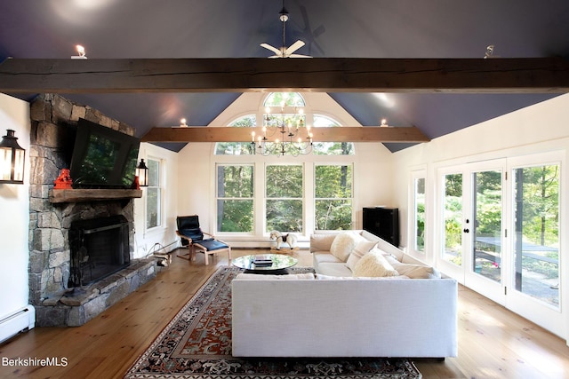 living room with baseboard heating, vaulted ceiling with beams, a fireplace, ceiling fan with notable chandelier, and light wood-type flooring