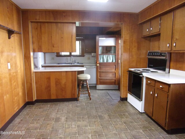 31 Millard Ave, Clarksburg, MA 01247 - kitchen featuring white appliances, brown cabinets, wooden walls, brick patterned floors, and light countertops