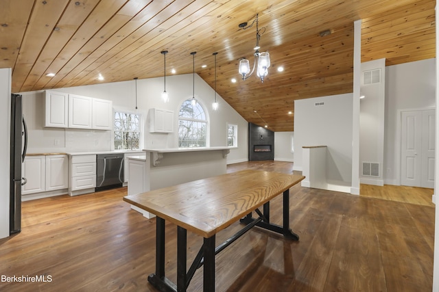 kitchen with stainless steel appliances, light countertops, white cabinetry, wooden ceiling, and decorative light fixtures