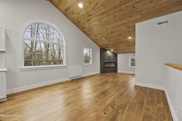 unfurnished living room featuring visible vents, a fireplace, light wood-style floors, and a healthy amount of sunlight