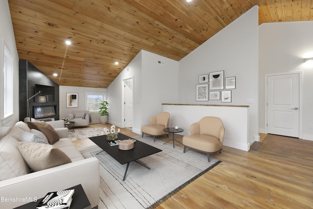 living room with wood ceiling, baseboards, wood finished floors, and high vaulted ceiling