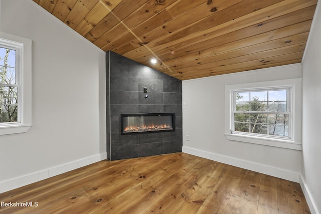 unfurnished living room featuring plenty of natural light, wooden ceiling, lofted ceiling, and a fireplace