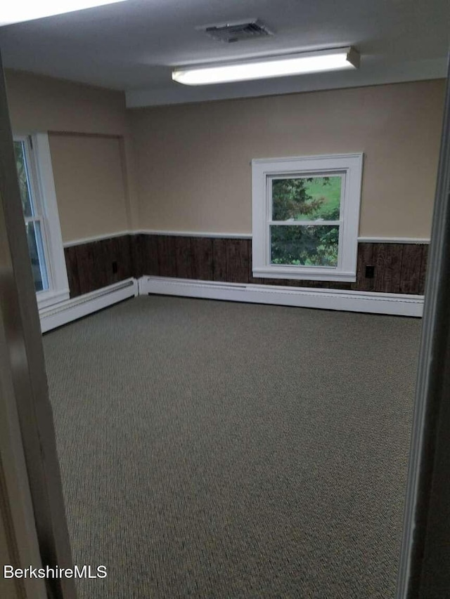 406 Main St, Great Barrington, MA 01230 - empty room with carpet floors, a wainscoted wall, and baseboard heating