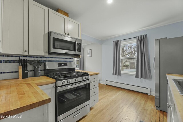 24 Henderson Rd, Williamstown, MA 01267 - kitchen featuring tasteful backsplash, butcher block countertops, a baseboard radiator, and appliances with stainless steel finishes