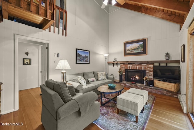 545 Leisure Lee Rd, Lee, MA 01238 - living room featuring high vaulted ceiling, wood finished floors, a ceiling fan, a brick fireplace, and beam ceiling