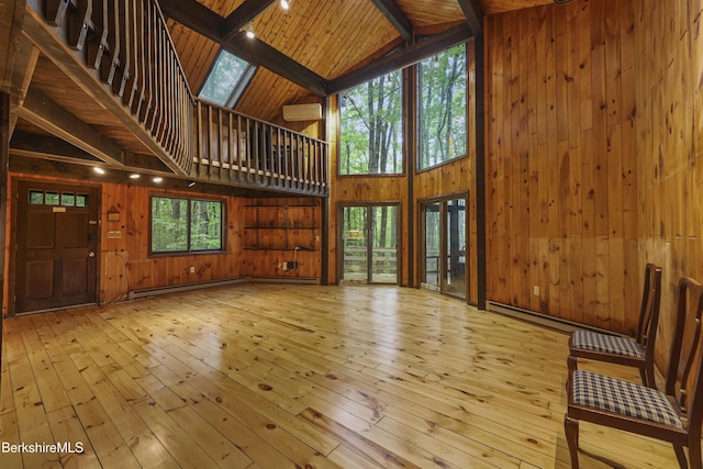 377 Highland Way, Sandisfield, MA 01255 - unfurnished living room featuring high vaulted ceiling, hardwood / wood-style floors, wood walls, a baseboard heating unit, and a wooden ceiling with exposed beams
