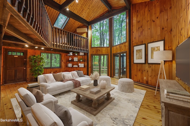 377 Highland Way, Sandisfield, MA 01255 - living area featuring high vaulted ceiling, wooden walls, light wood-style flooring, a wood ceiling with exposed beams, and a baseboard radiator
