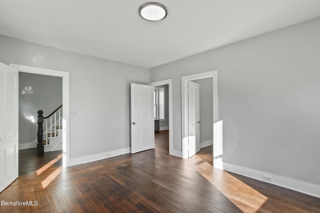 unfurnished bedroom featuring baseboards and hardwood / wood-style flooring