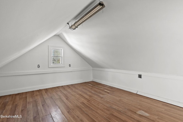 bonus room with baseboards, wood finished floors, and vaulted ceiling