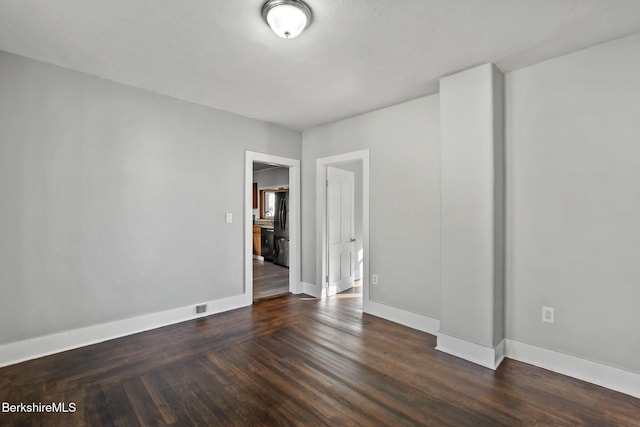 unfurnished room with baseboards and wood finished floors