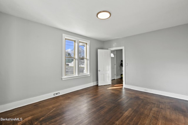 empty room with baseboards and wood finished floors