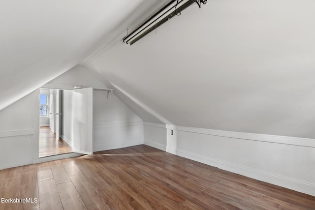 additional living space with lofted ceiling and wood finished floors