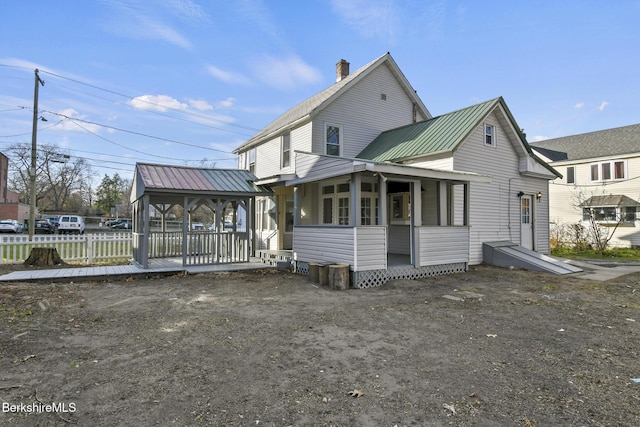 exterior space featuring metal roof and fence