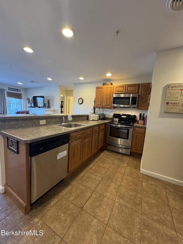 kitchen featuring tile patterned floors, kitchen peninsula, sink, and stainless steel appliances