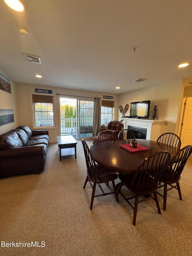 dining space featuring light carpet