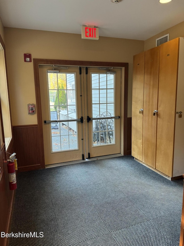 doorway featuring french doors and wooden walls