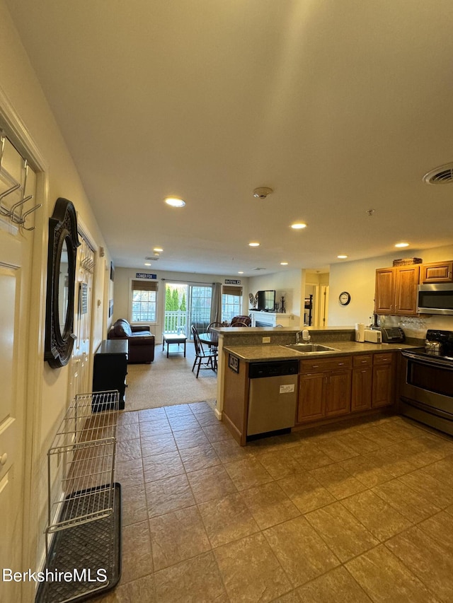 kitchen with kitchen peninsula, sink, and appliances with stainless steel finishes