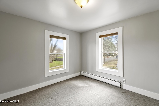spare room with a baseboard heating unit, carpet flooring, and baseboards