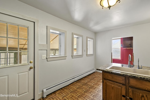 interior space featuring a baseboard radiator, brown cabinetry, and a sink