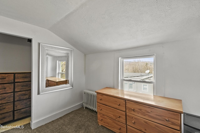 bedroom with vaulted ceiling, radiator, baseboards, dark carpet, and a textured ceiling