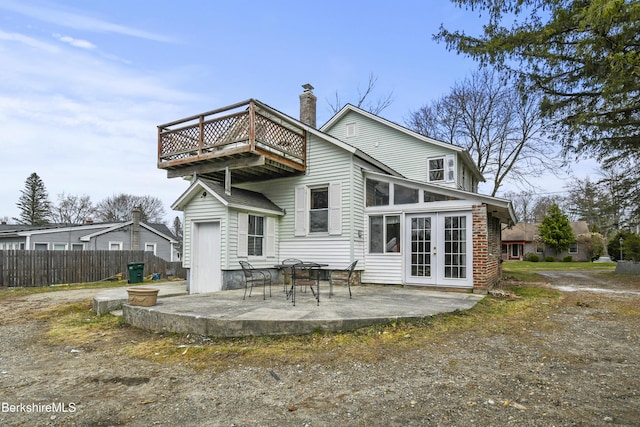 rear view of property featuring a patio, fence, french doors, and a chimney