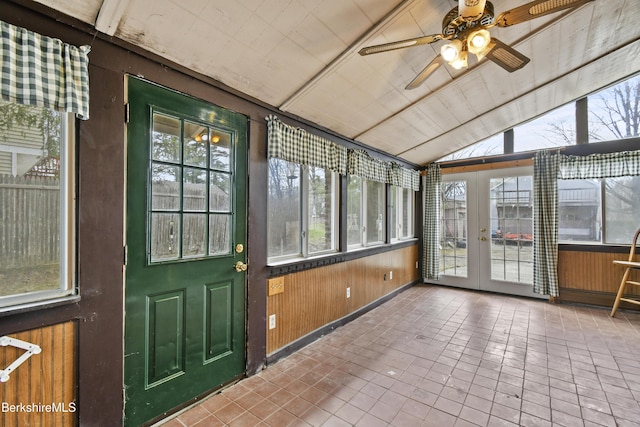 unfurnished sunroom featuring a ceiling fan and french doors