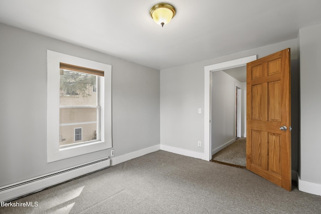 carpeted spare room featuring baseboard heating and baseboards