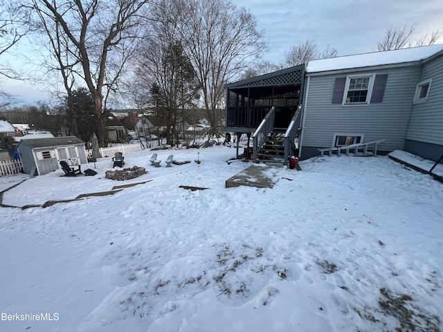 yard layered in snow with a storage unit