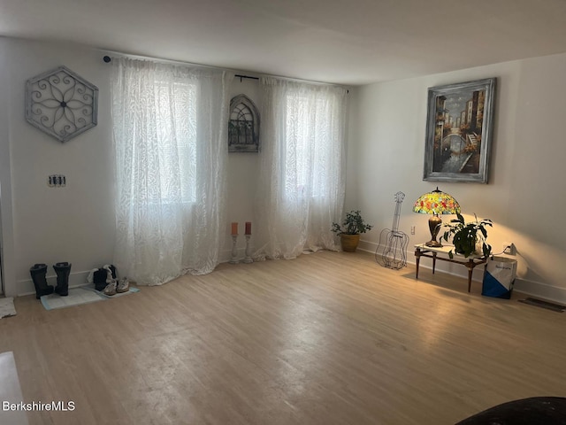 interior space with wood finished floors, visible vents, and baseboards