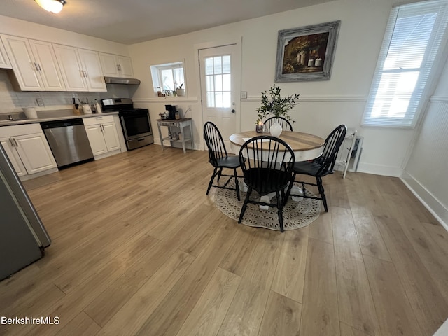 dining room featuring baseboards and light wood-style flooring