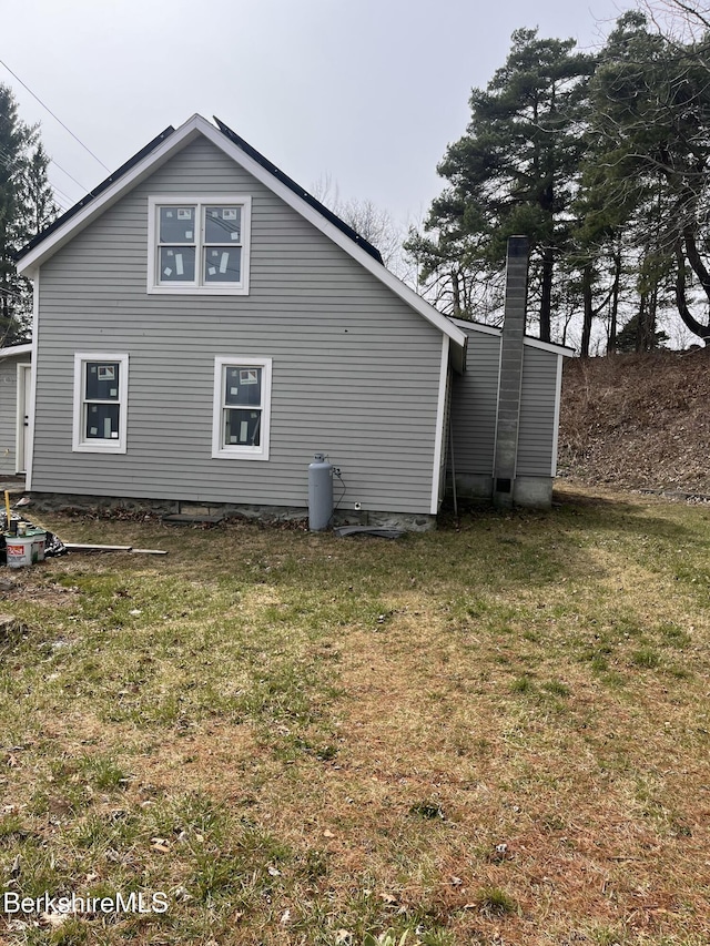back of house with a lawn