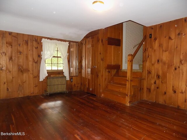 350 Laurel St, Lee, MA 01238 - empty room with radiator heating unit, wood finished floors, stairway, wood walls, and lofted ceiling