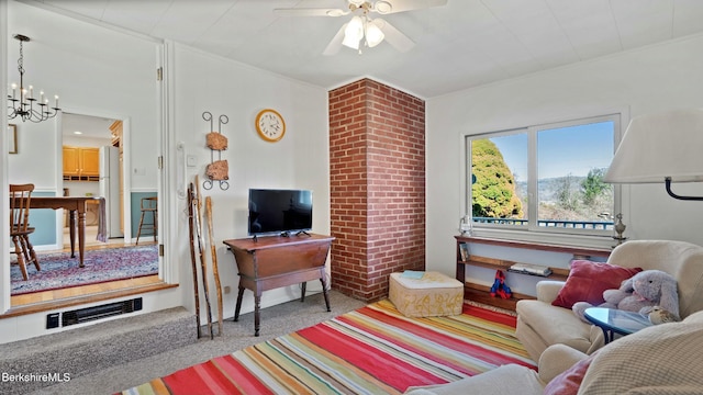 living room featuring ornamental molding, visible vents, and ceiling fan with notable chandelier