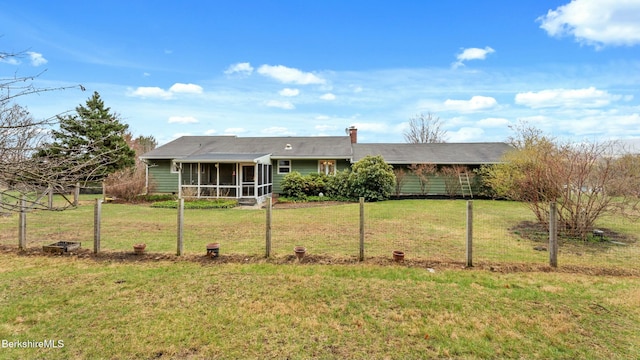 ranch-style home with a front yard, a carport, a sunroom, and a chimney