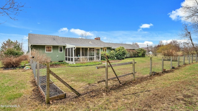 rear view of property with fence, a yard, roof with shingles, and a sunroom